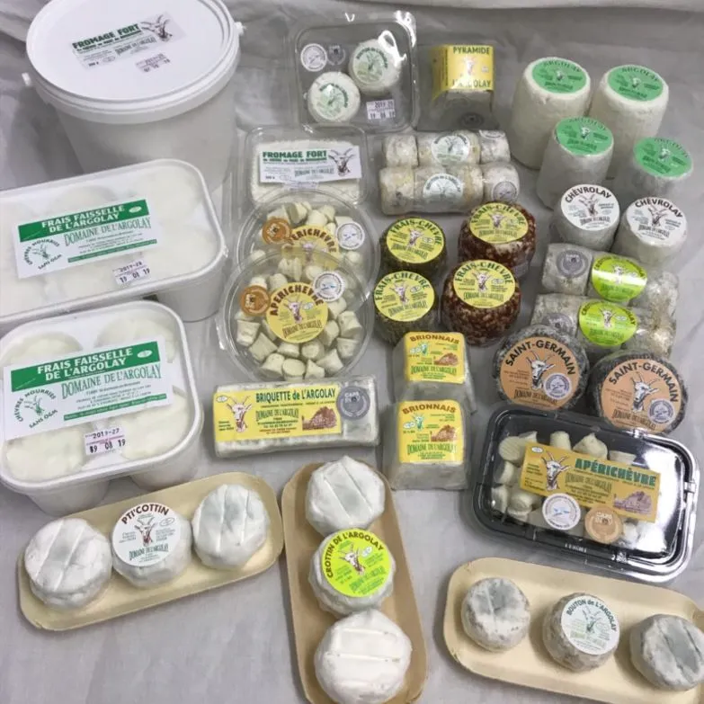 Boîtes de fromages devant l'enseigne en forme de chèvre du Domaine de l'Argolay