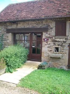 Entrée en pierre de la ferme avec porte en bois